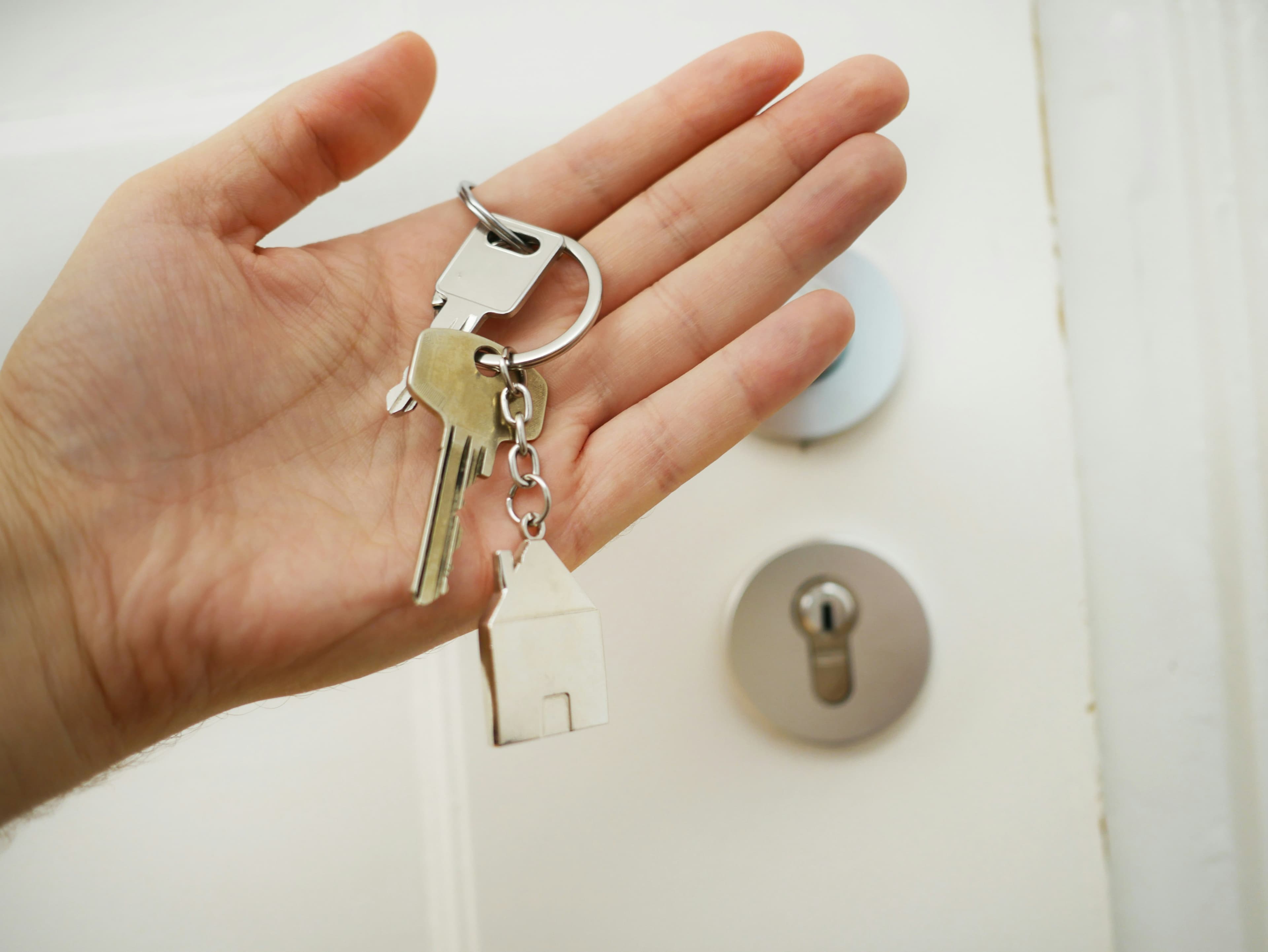 A set of house keys resting in an open hand, representing the decision to accept or decline an offer.