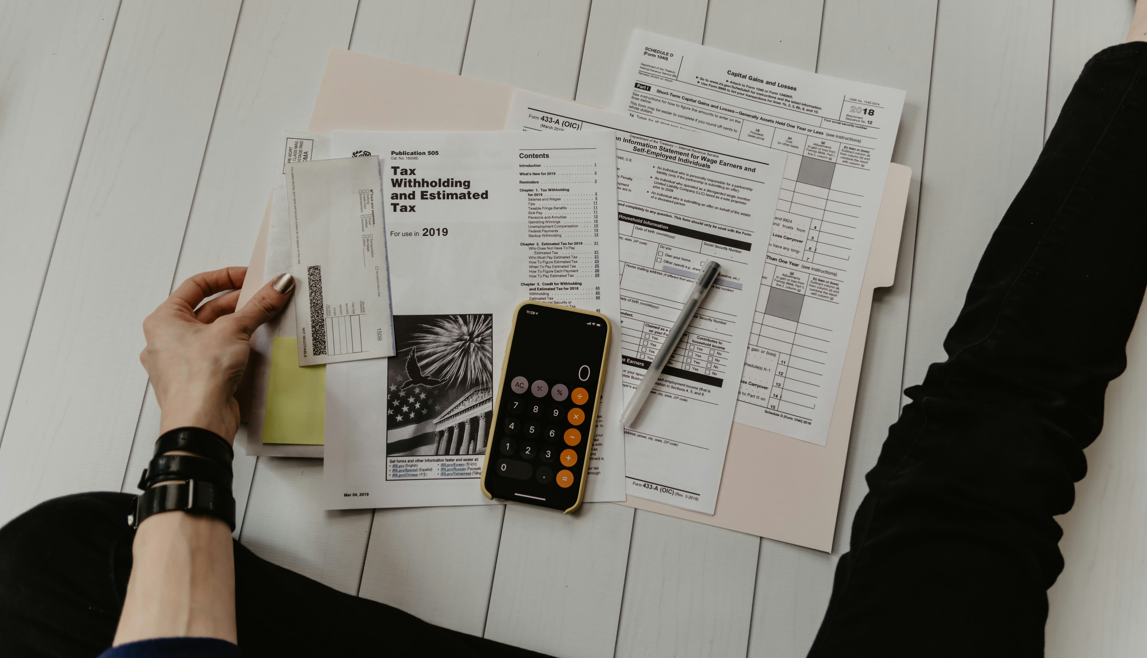 A calculator, pen and financial charts on a desk, representing different ways of measuring house prices