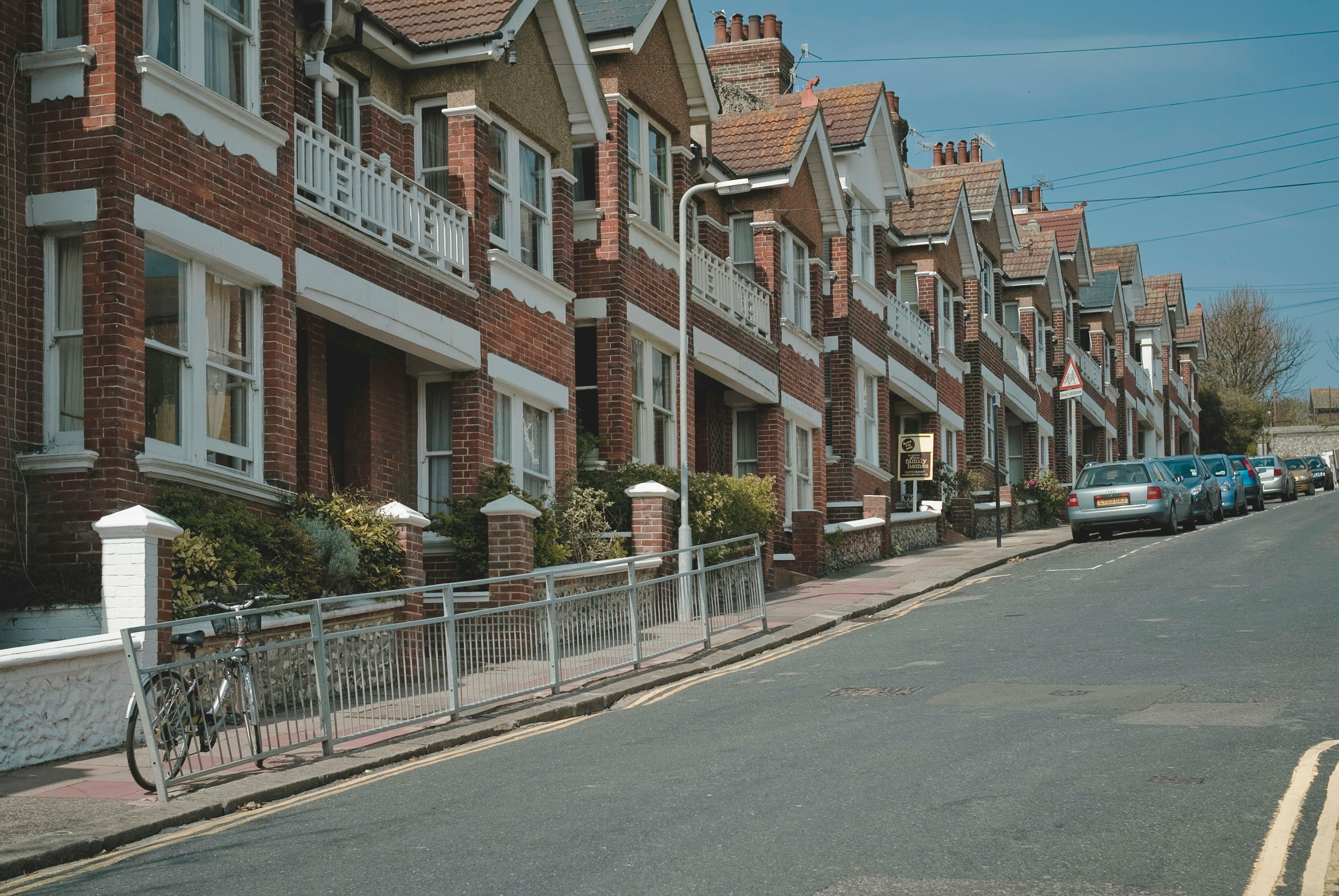 Two similar houses side by side on a UK residential street, one likely worth more than the other