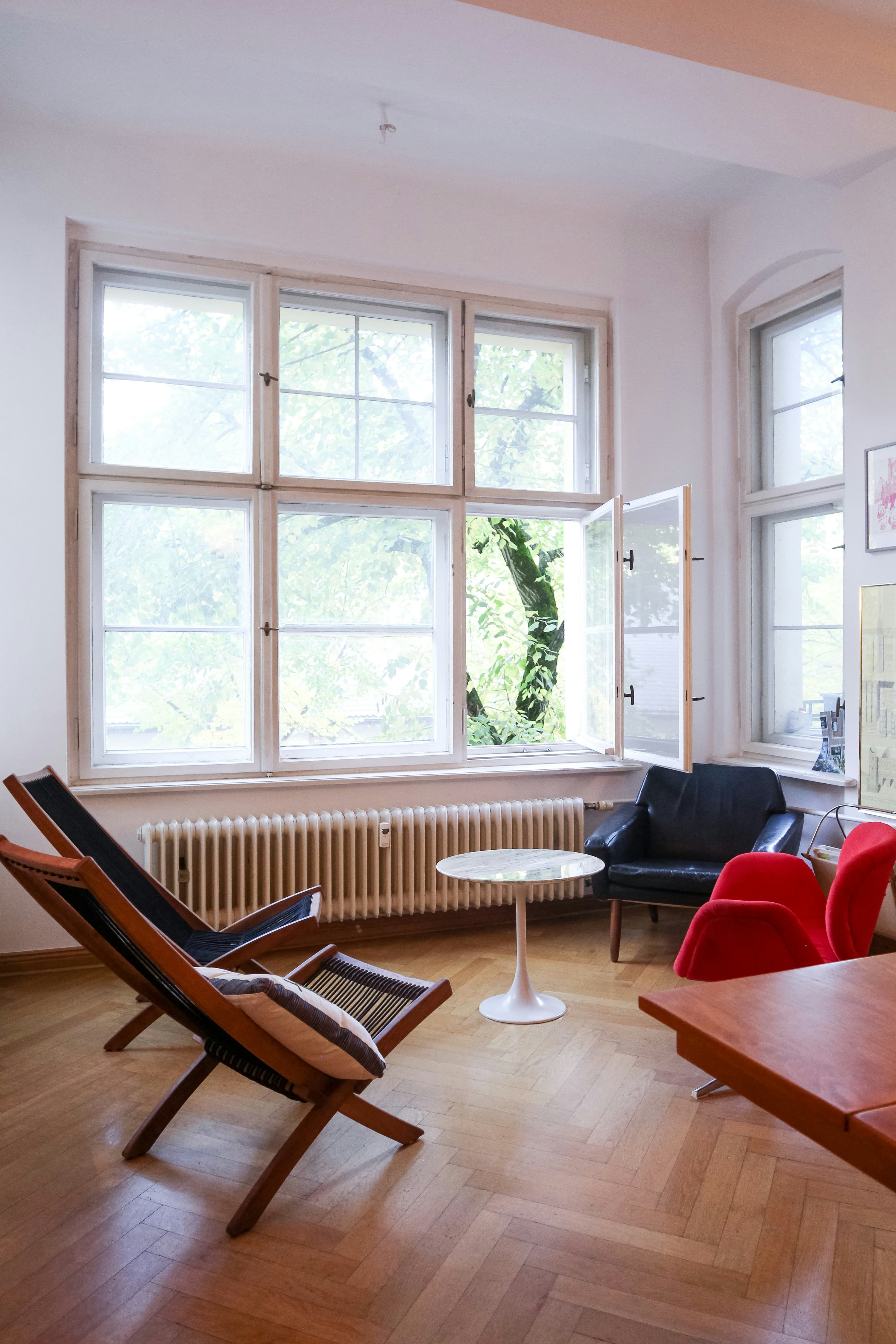 A red padded armchair beside a white-framed window in a quiet family home