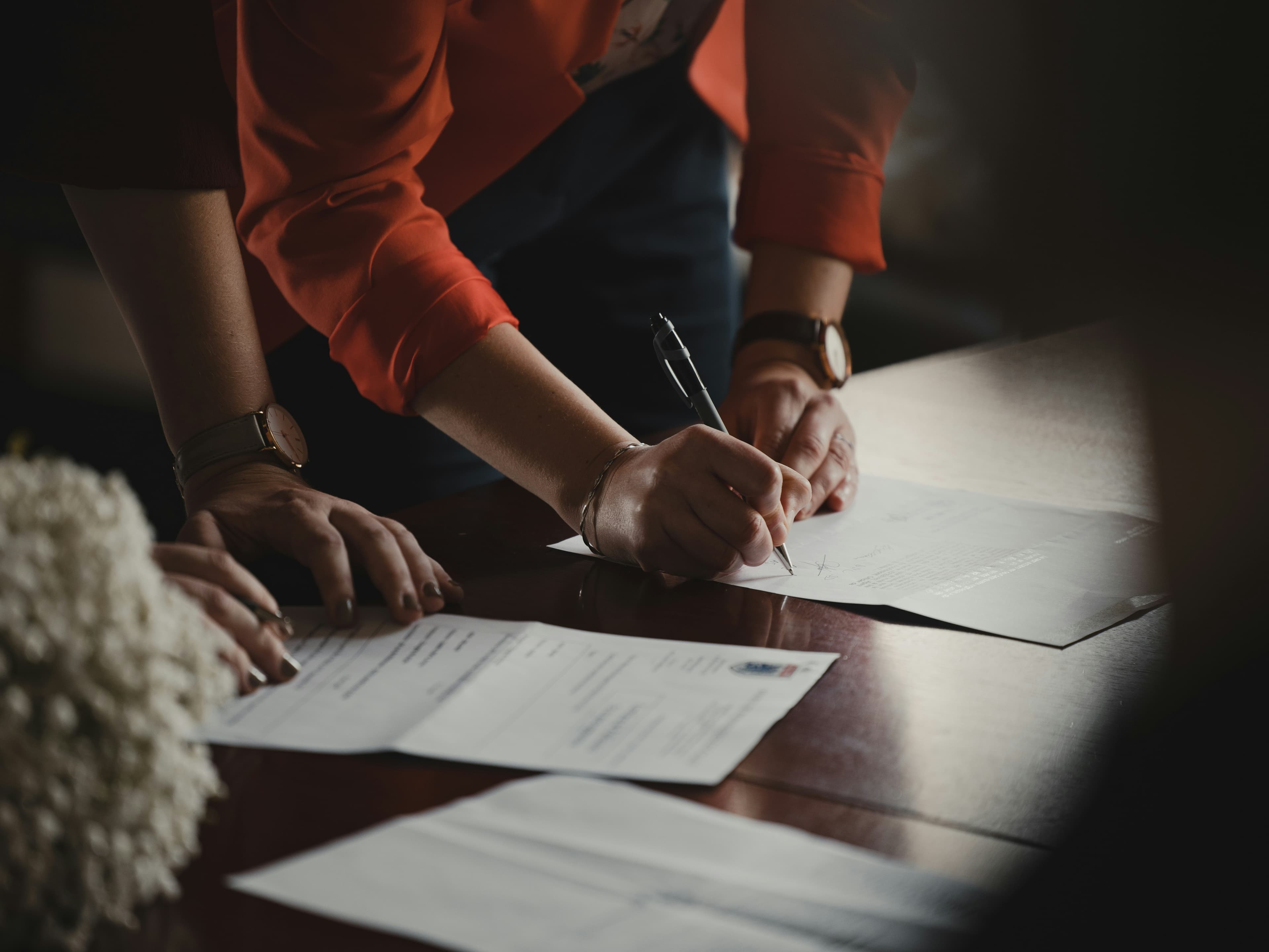 Property paperwork and a pen on a desk, representing legal enquiries during a house sale.