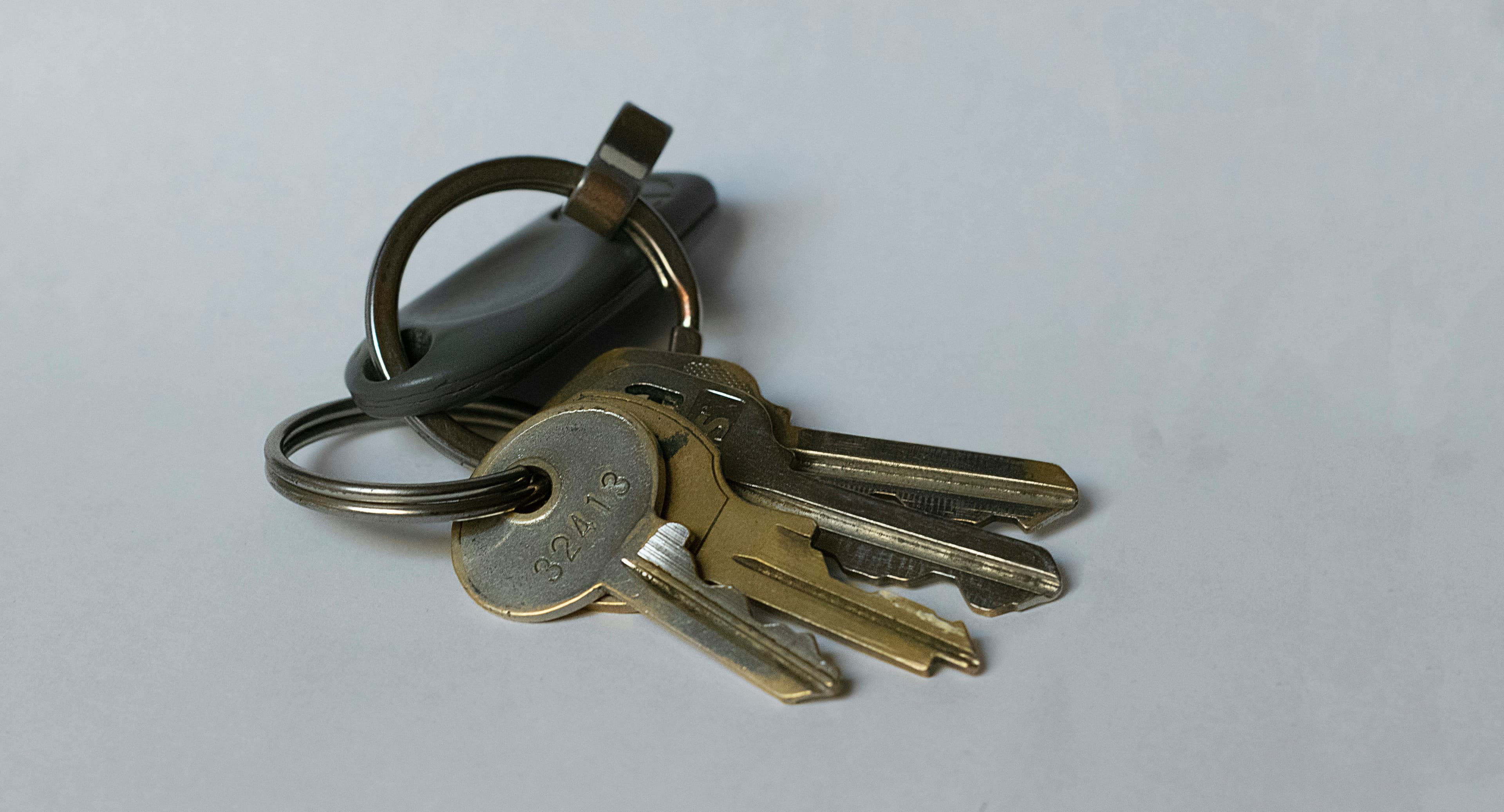 A set of house keys resting on a plain table, representing a sale moving towards completion