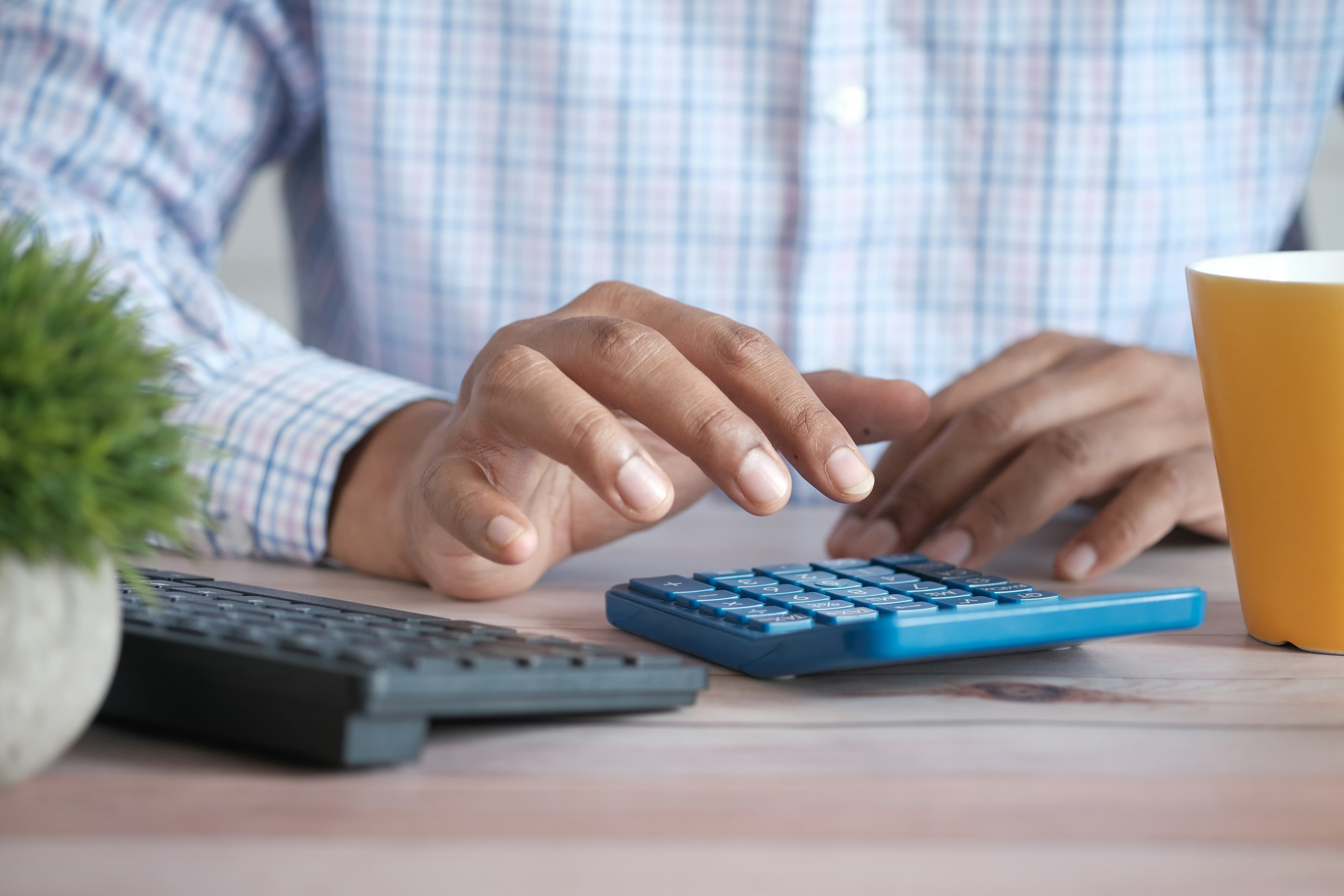 A person going through household finances with a calculator and paperwork