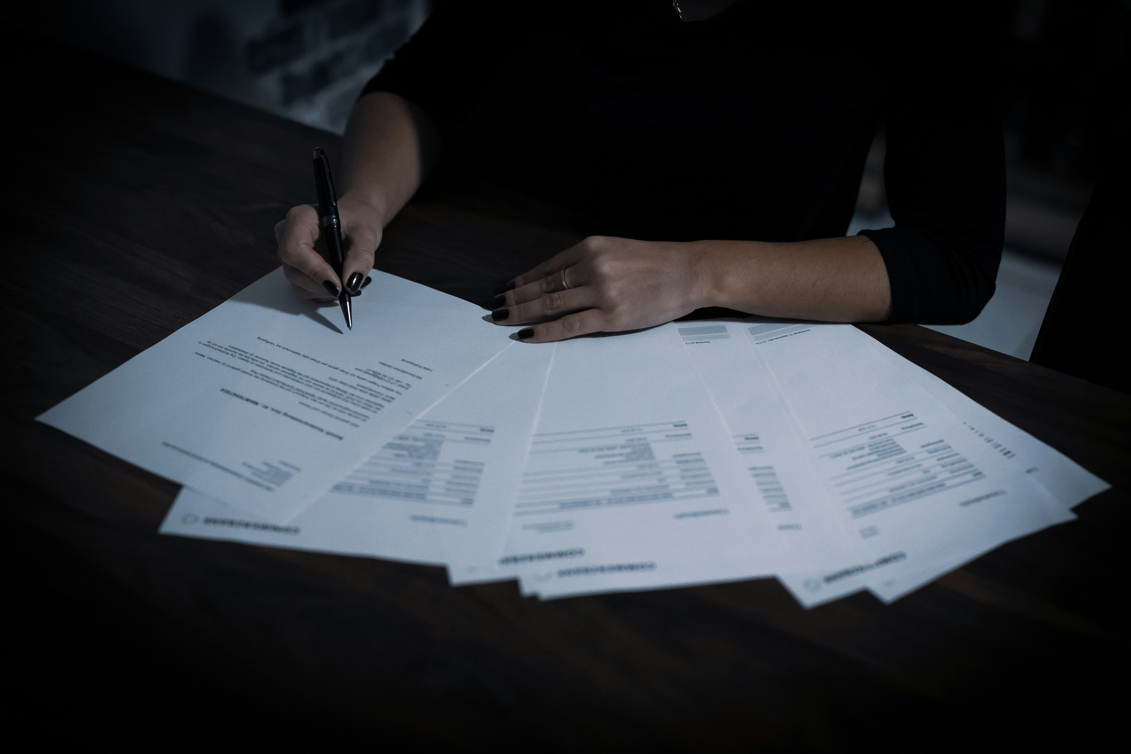 A person reviewing mortgage and finance paperwork at a desk