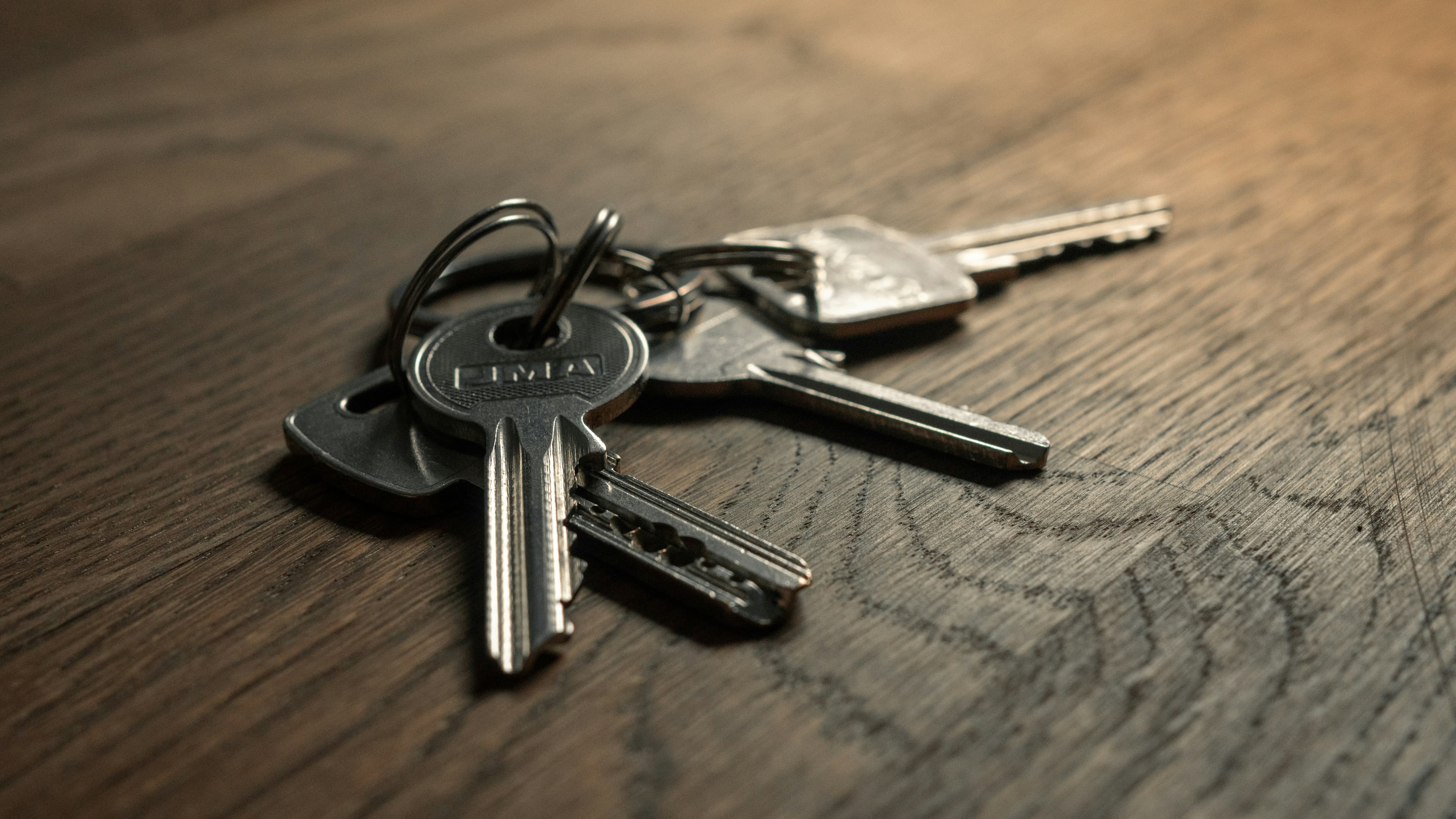 A set of house keys resting on a wooden table