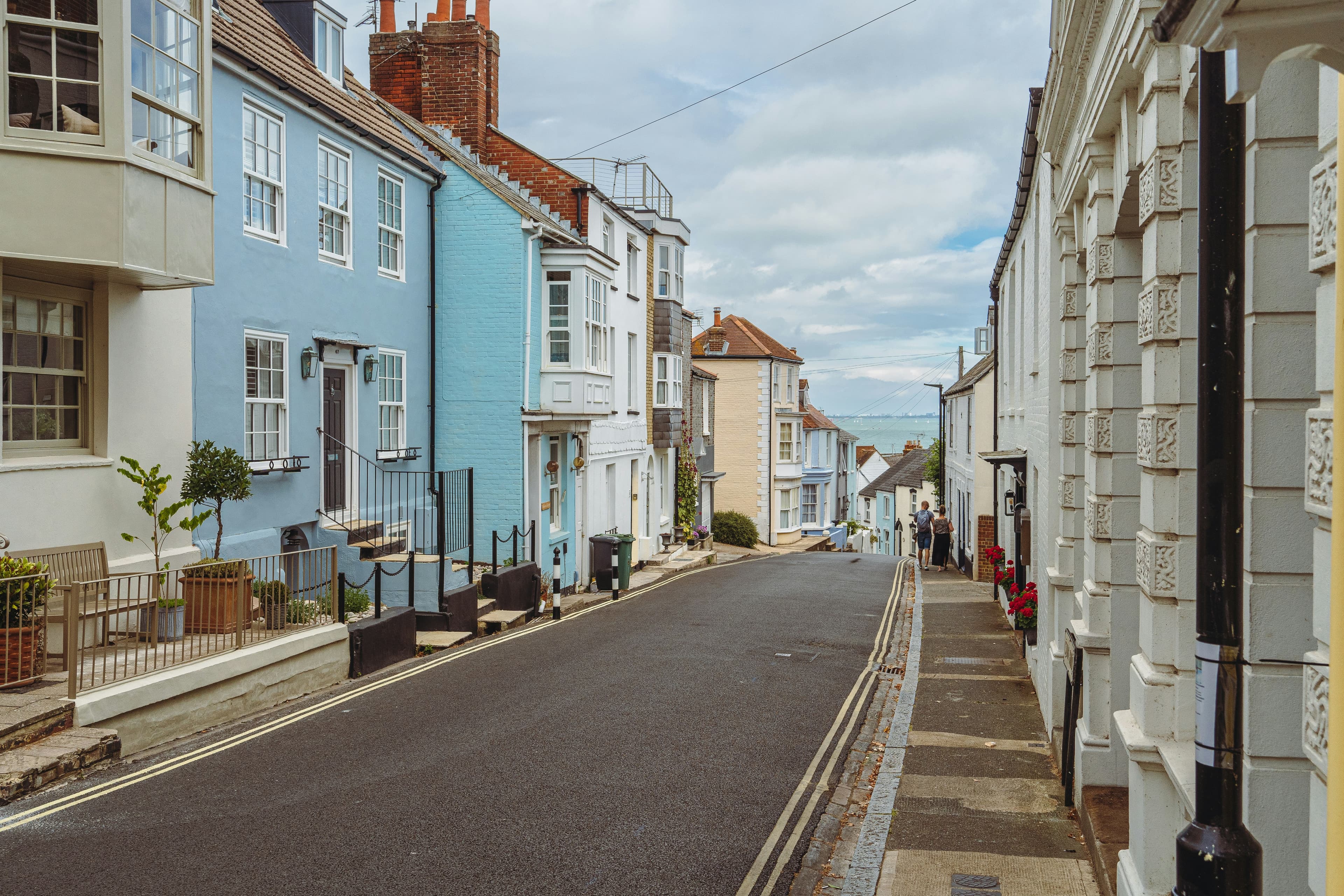 A British residential street lined with houses on both sides under a grey sky