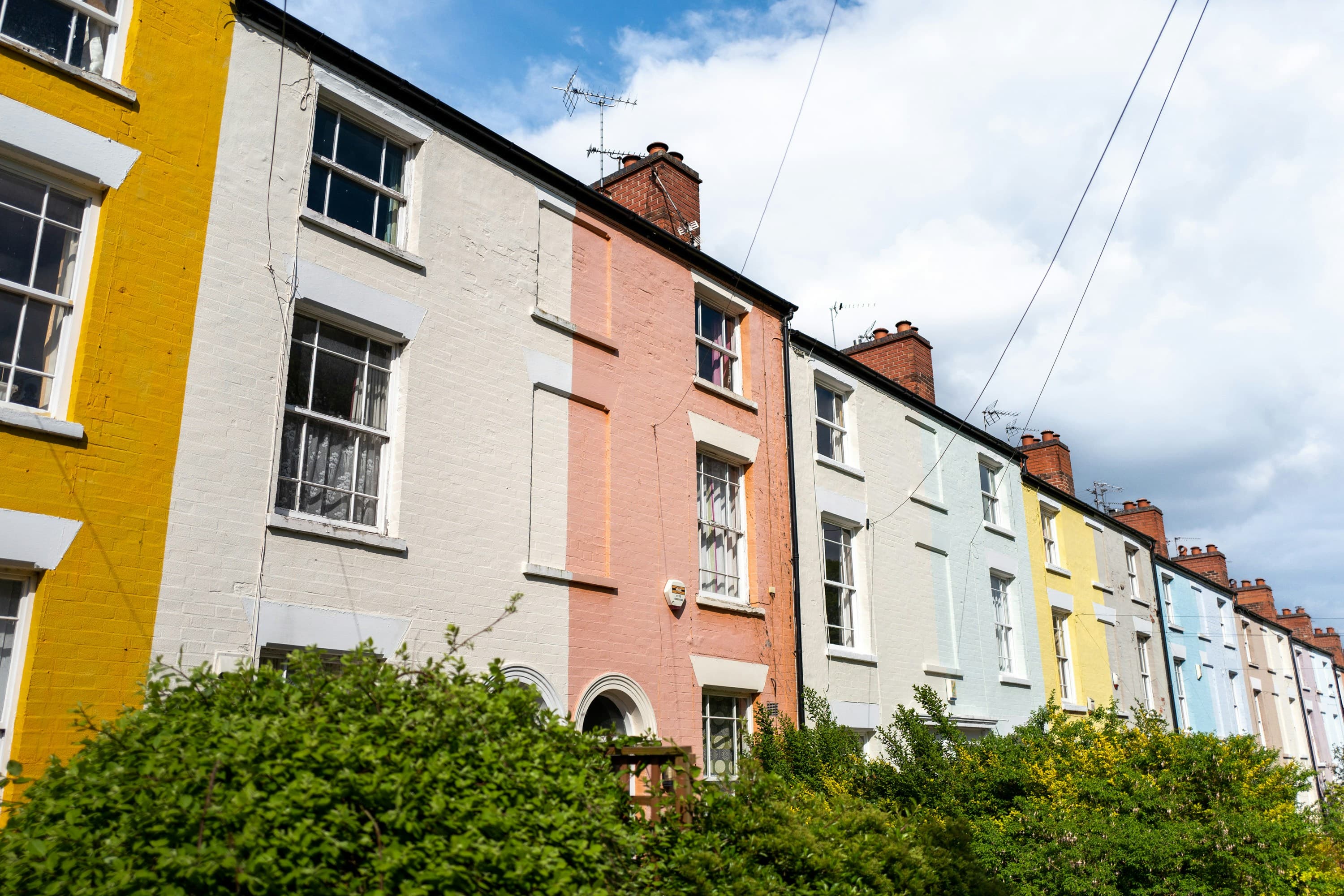 A row of multi-coloured terraced houses in a residential street
