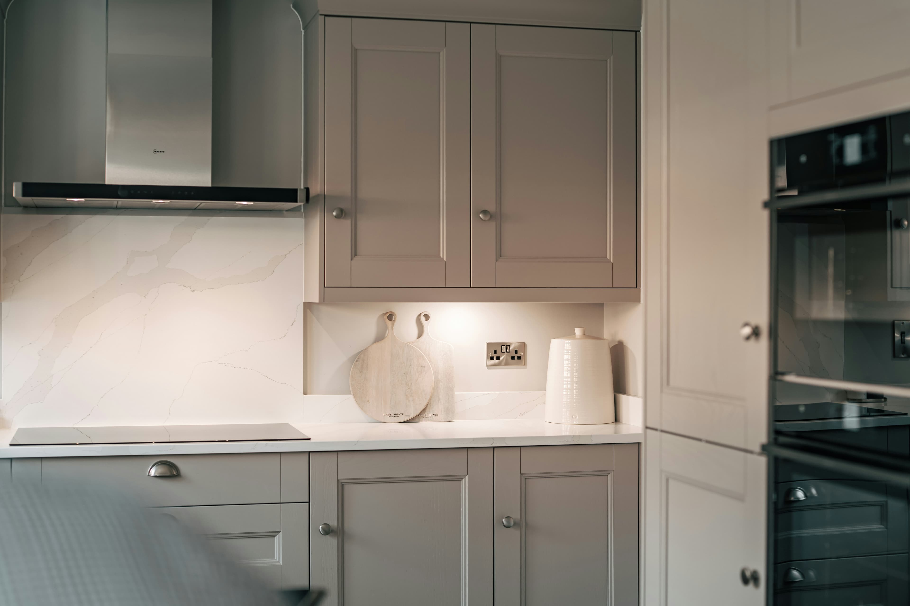 A fitted kitchen with white built-in cabinets and a black oven, the kind of fixture that stays with a house when it is sold