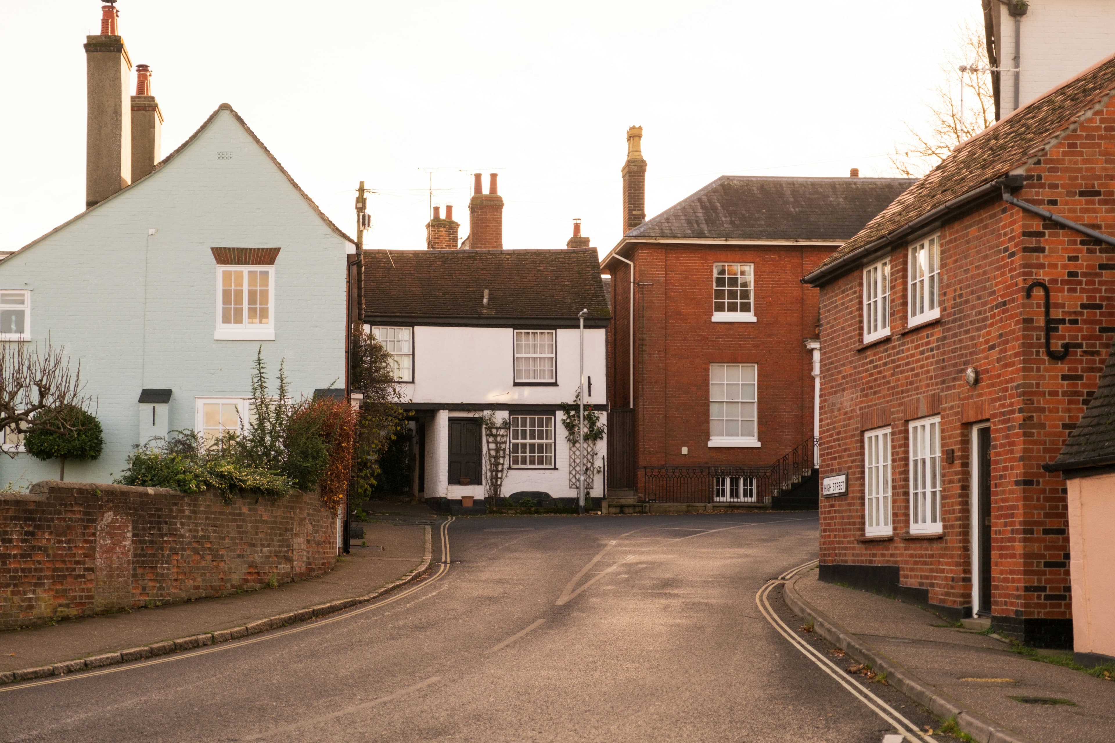A residential street of houses with a van parked at the roadside