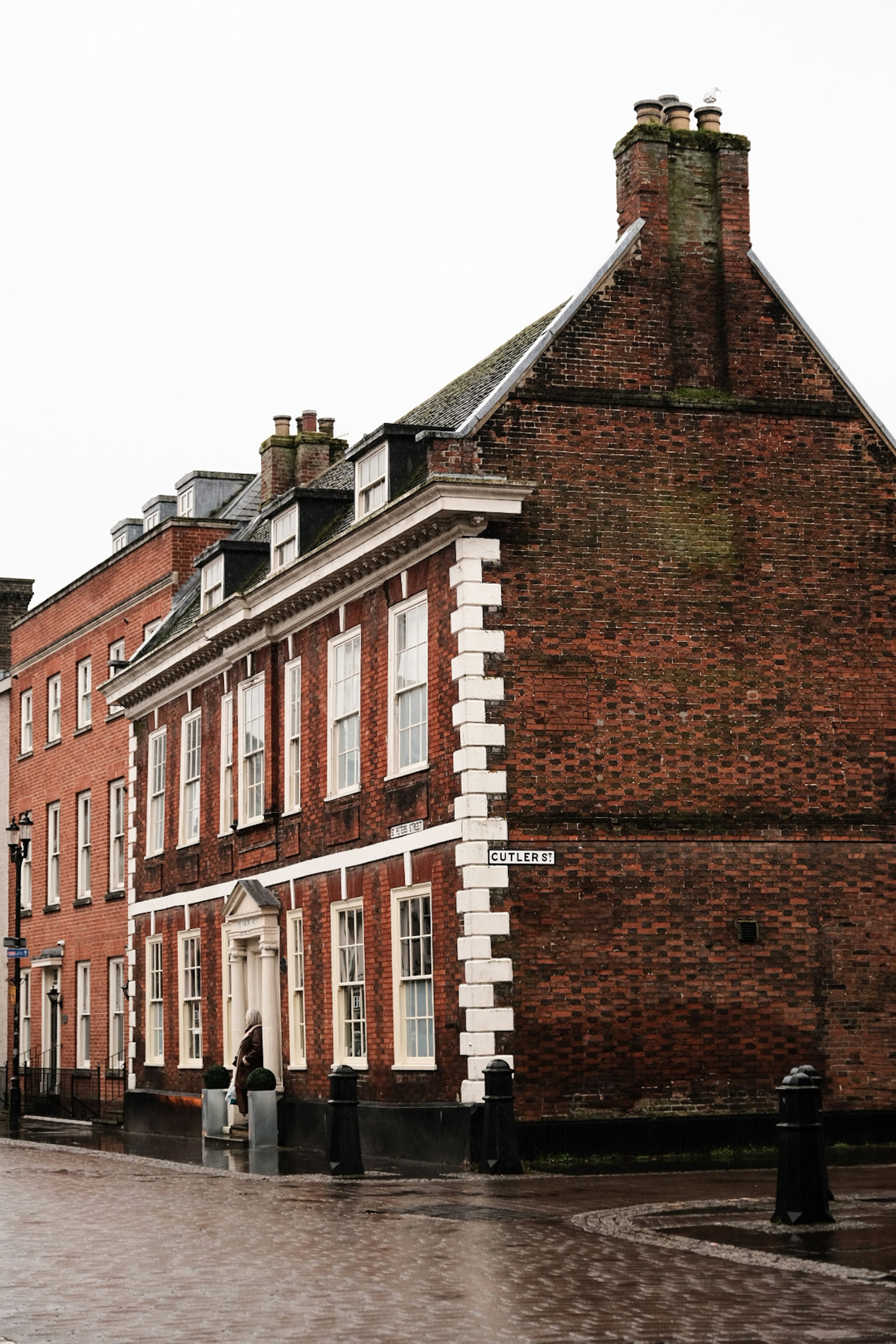 A row of brick high street buildings on a rainy day in England