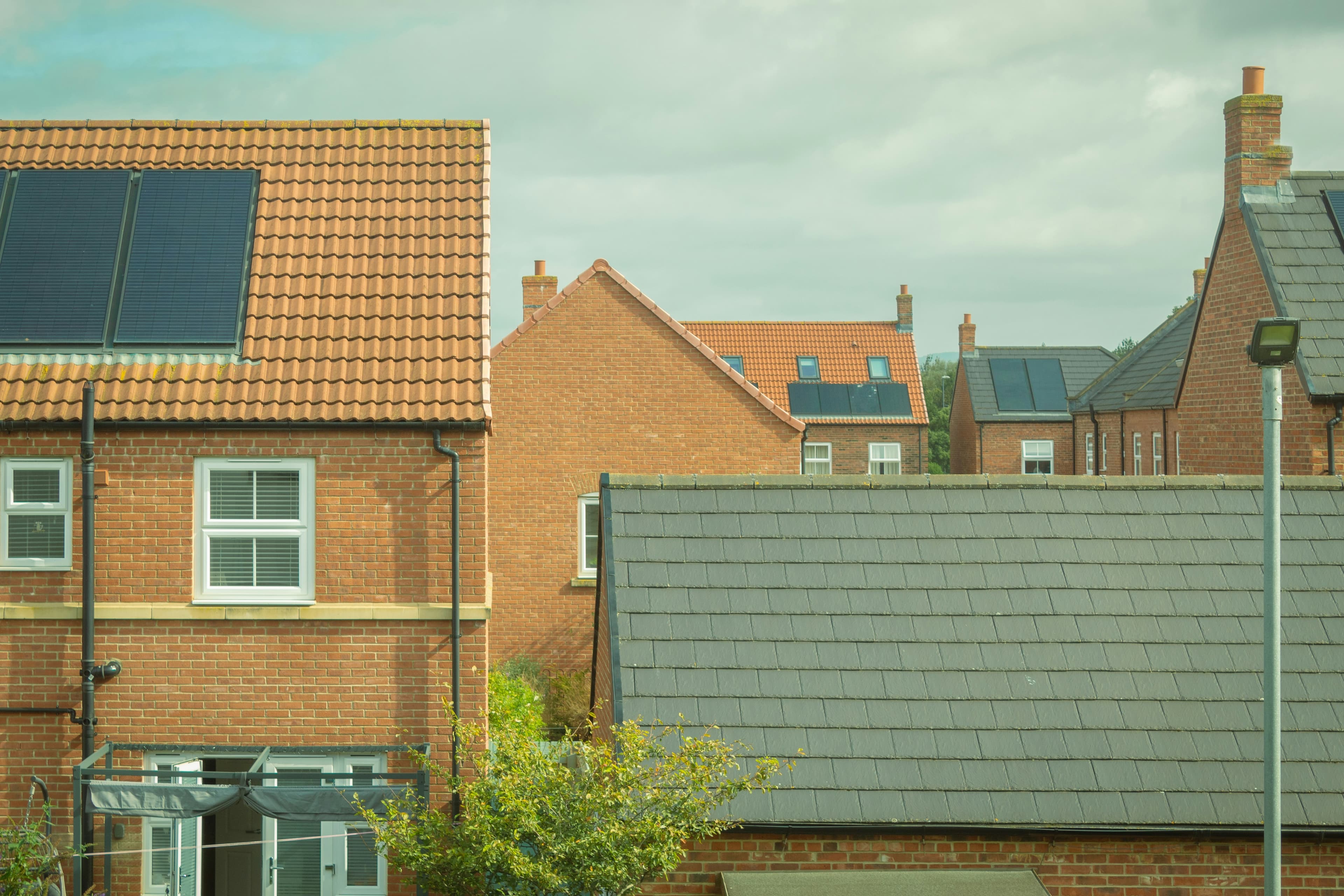 A row of newly built family homes with solar panels on their roofs