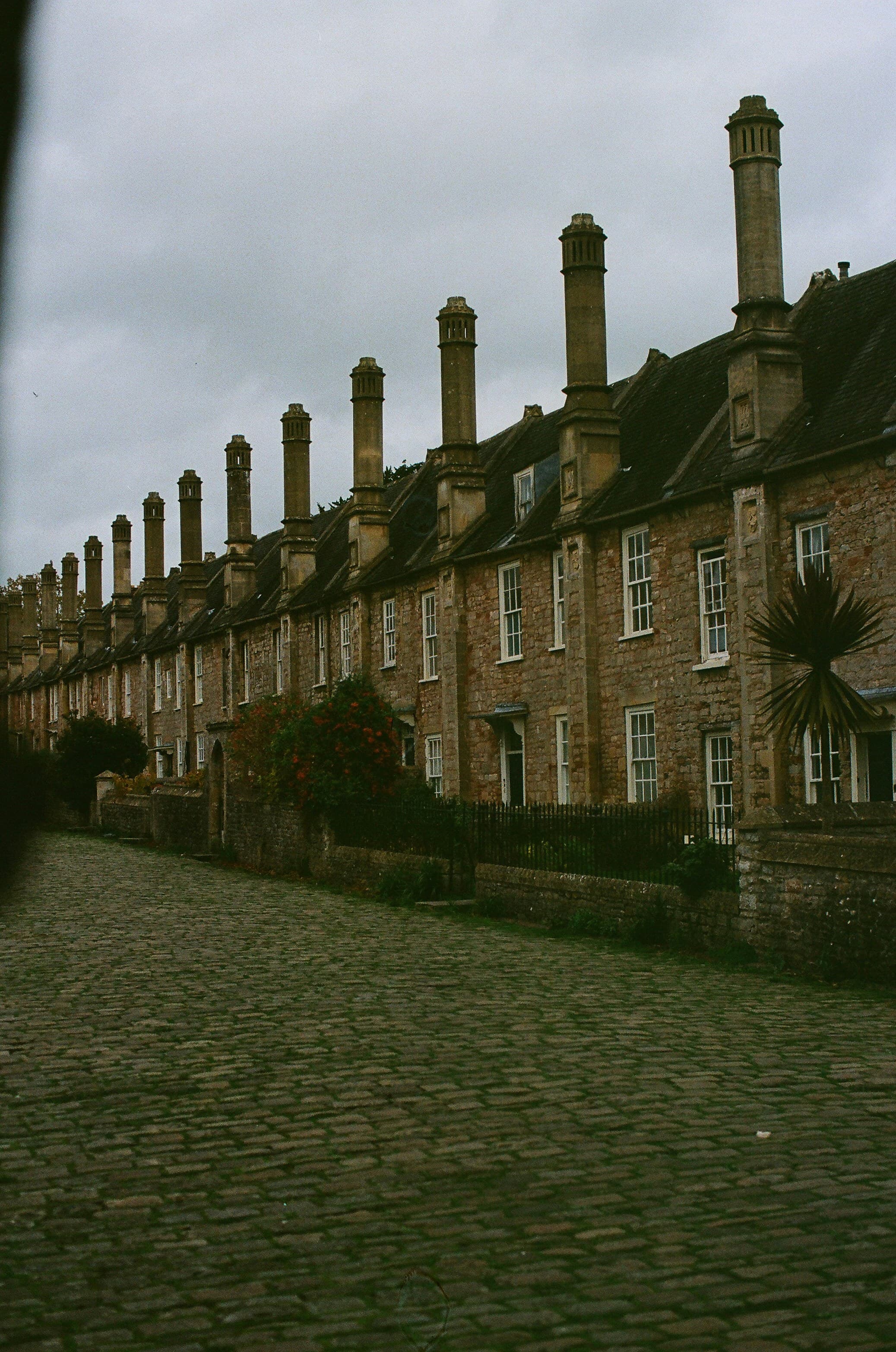 A row of historic brick terraced houses with tall chimneys in England
