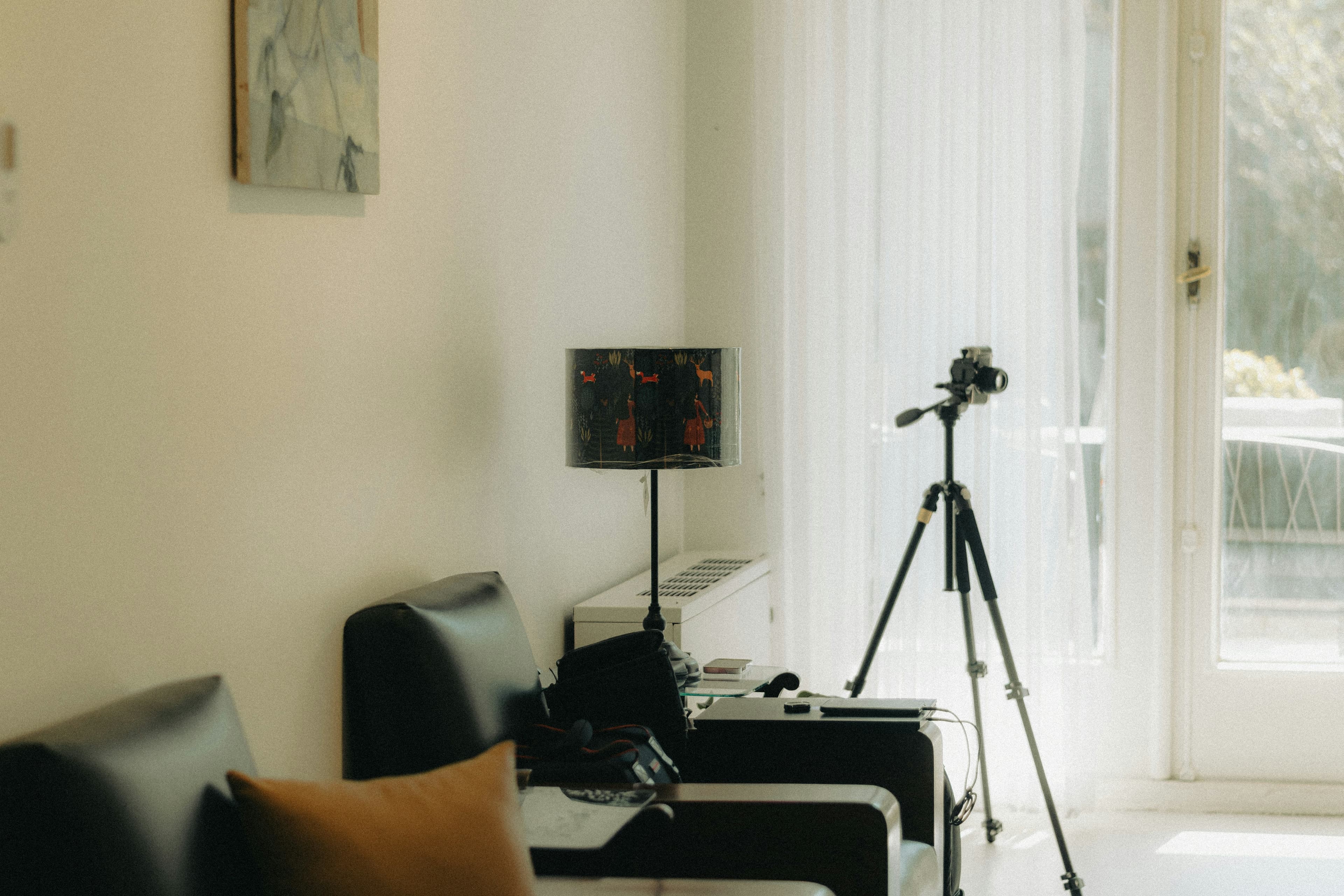 A camera on a tripod set up to photograph a bright living room