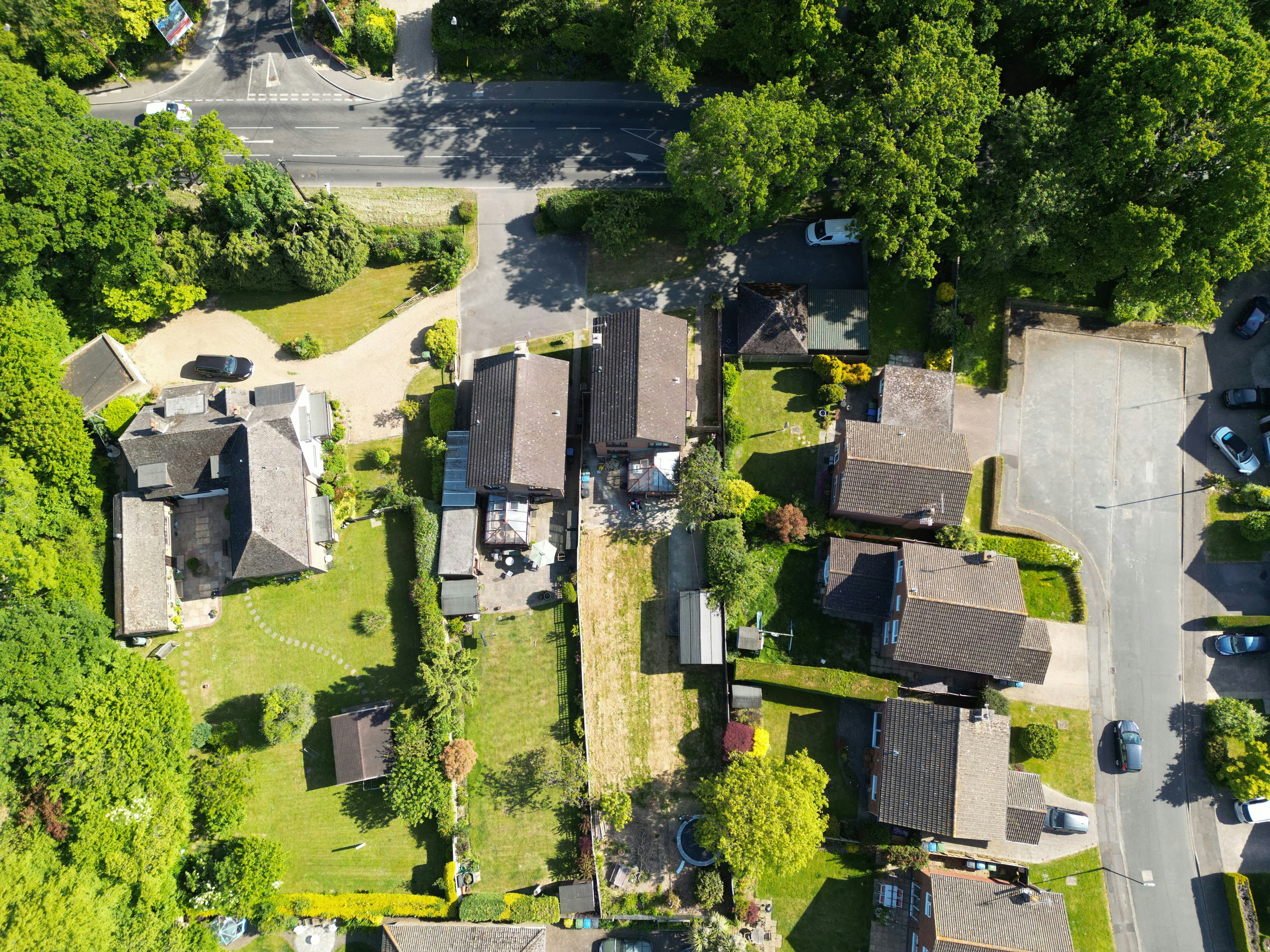 Aerial view of a residential area with houses, gardens, roads and trees