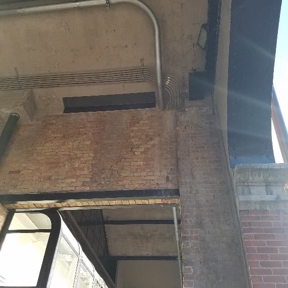 A stepped diagonal crack running through the mortar joints of a brick wall