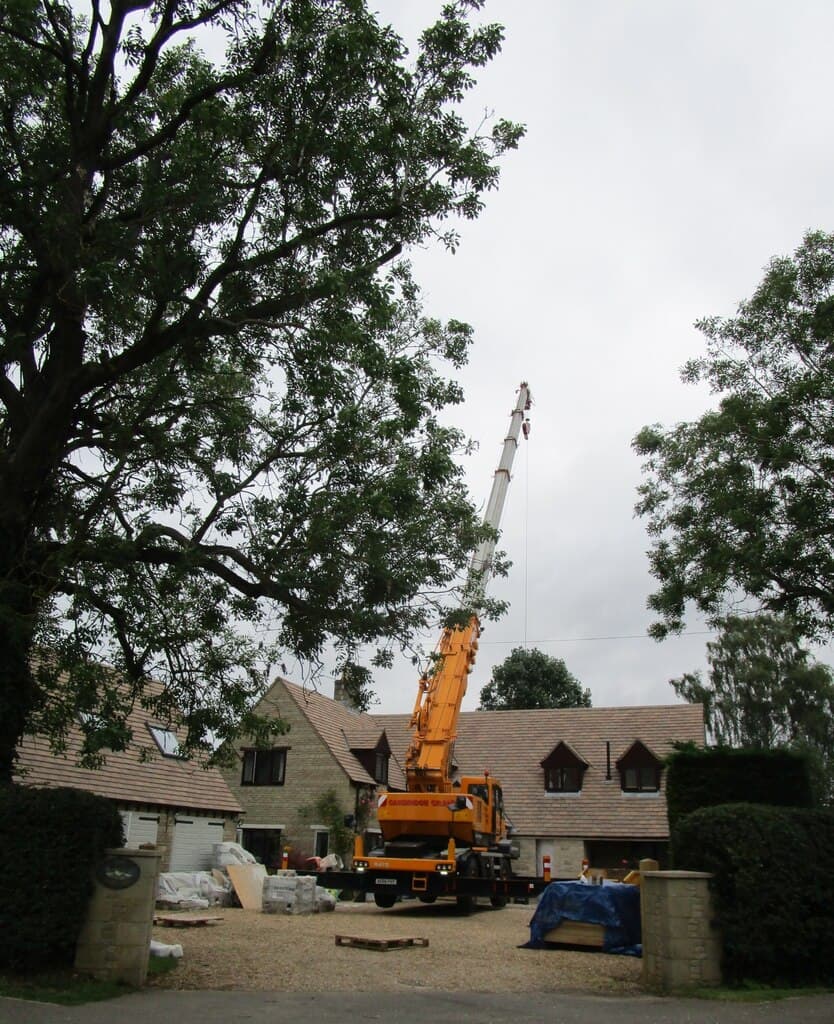 A partly built single storey extension at the rear of a house, with scaffolding and building materials in the garden