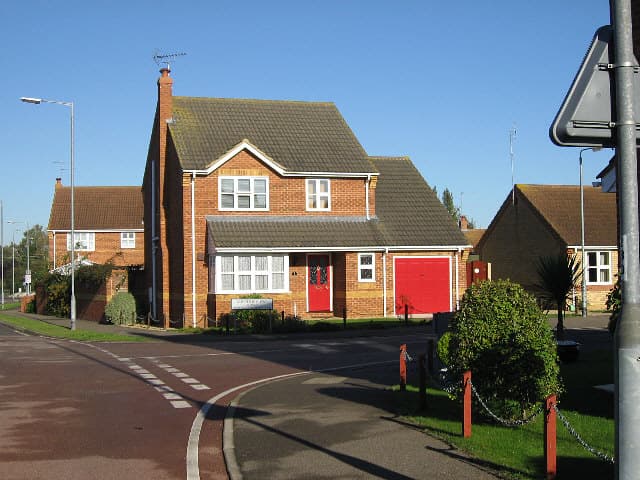A row of newly built houses on a UK estate under a bright sky