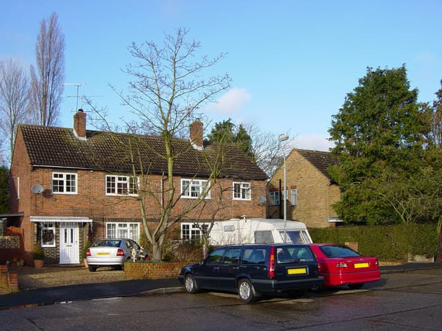 Houses on a UK residential street with cars parked on driveways in front of them
