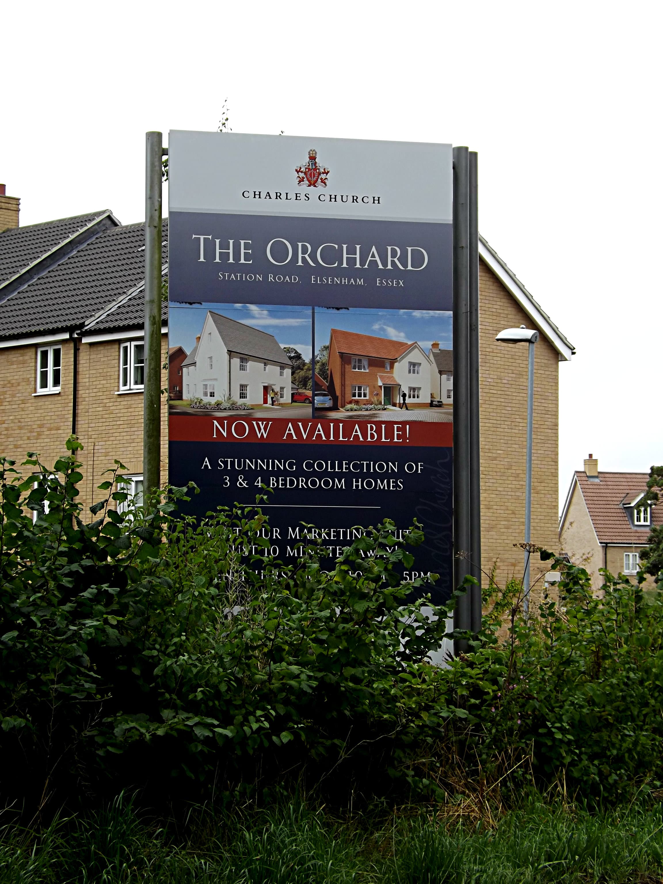 A for sale board outside a house in England, weathered after a long spell on the market