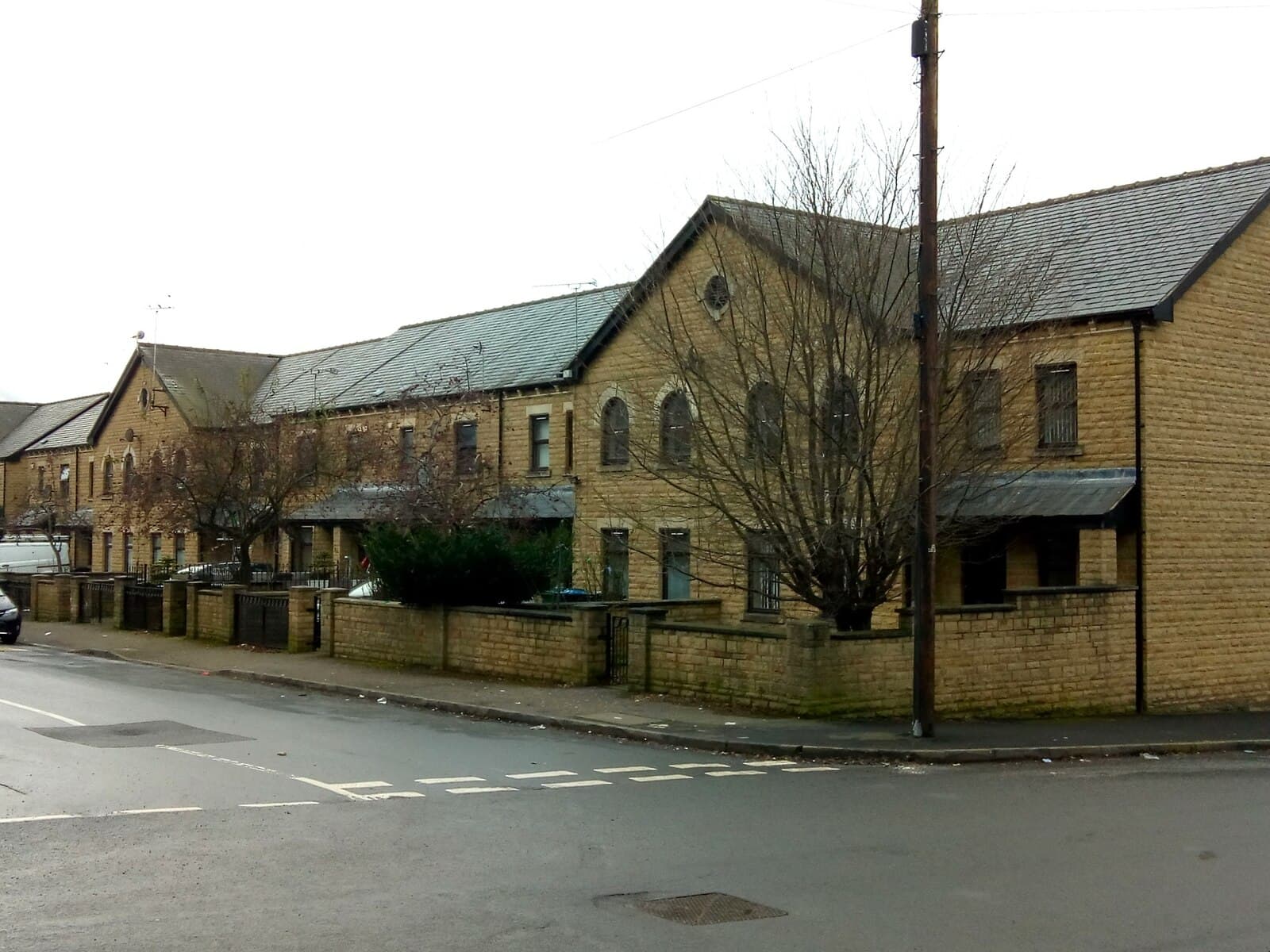 A terrace of modern stone-built homes with slate roofs and low front walls on Edderthorpe Street, Bradford
