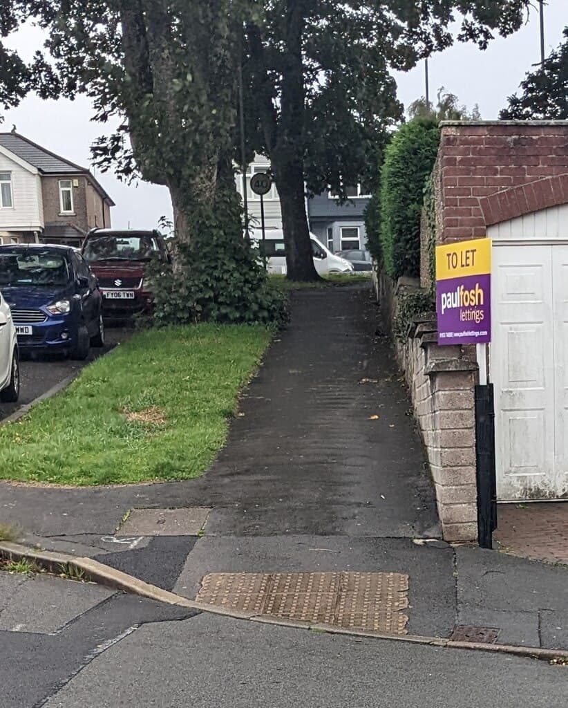 A To Let board fixed to a post on a residential street corner
