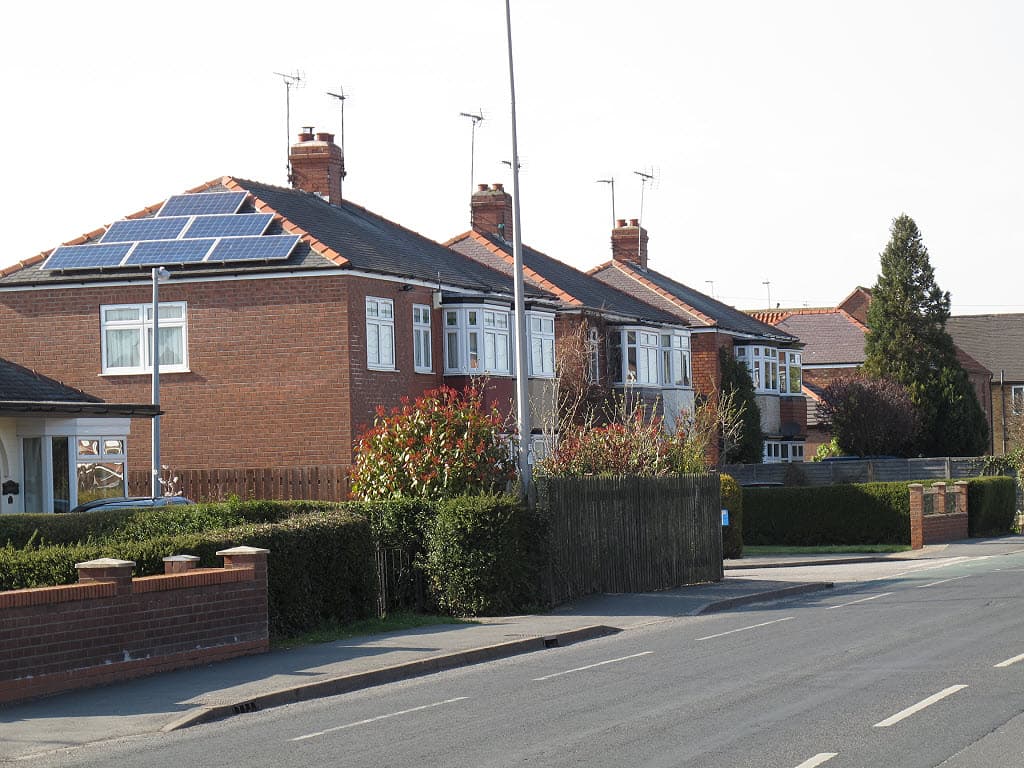 Solar panels fitted across the tiled roof of a house in England