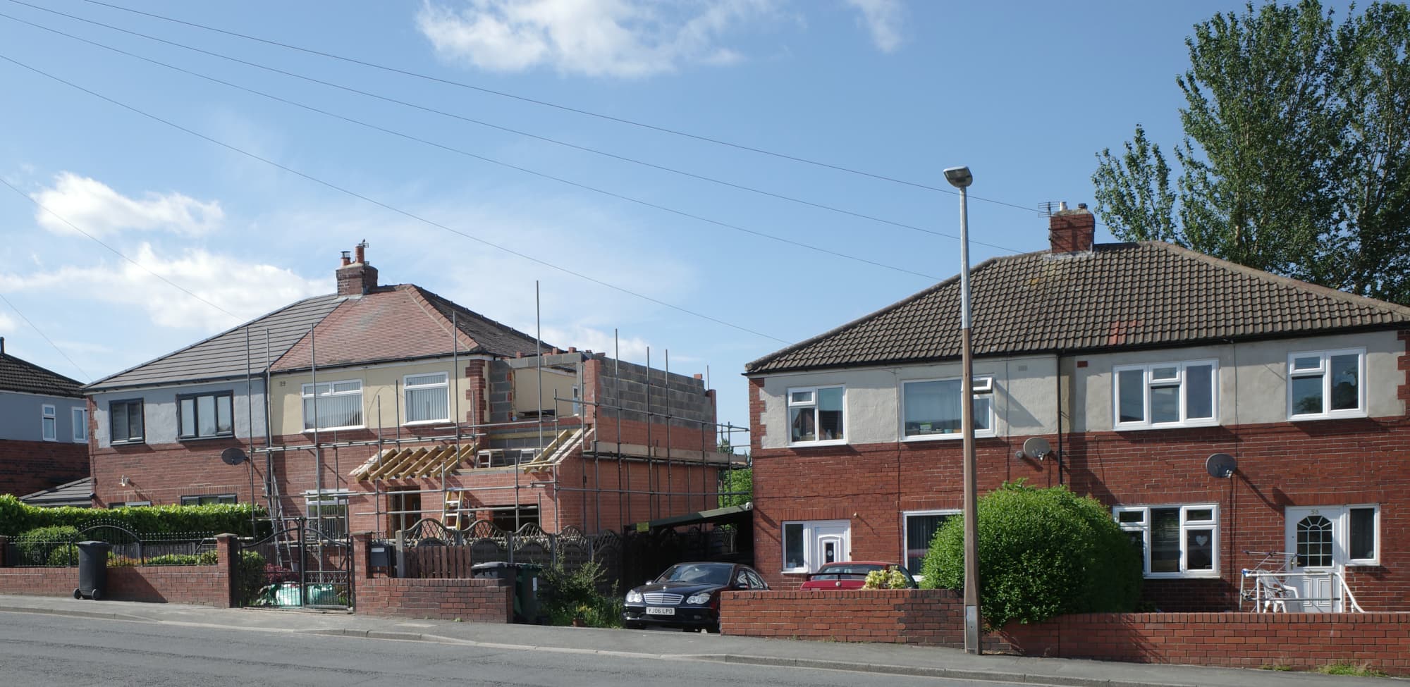 A single storey house extension under construction with brickwork and scaffolding in place